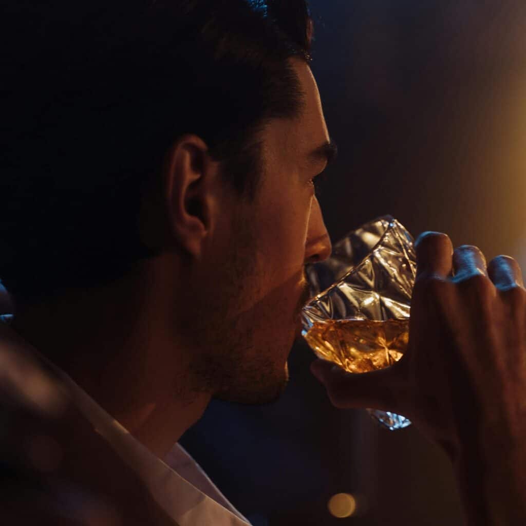 man holding glass of liquor